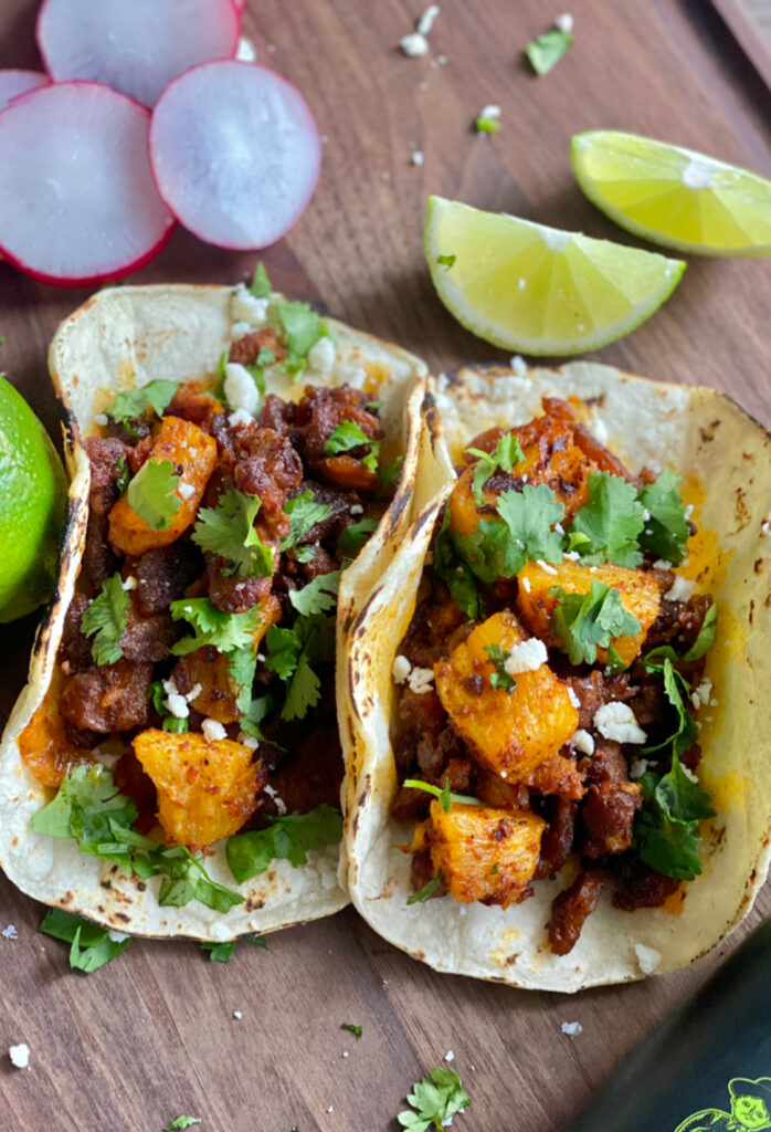 Delicious Al Pastor tacos with pineapple and fresh cilantro served on corn tortillas